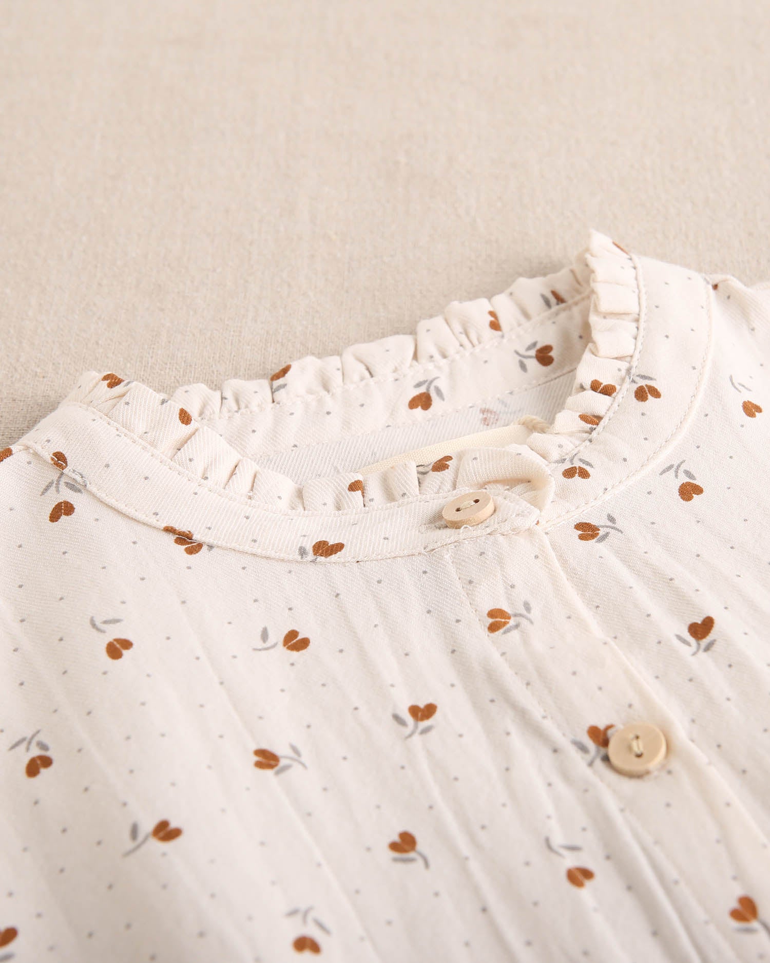 Blusa de niña beige con flores marrones