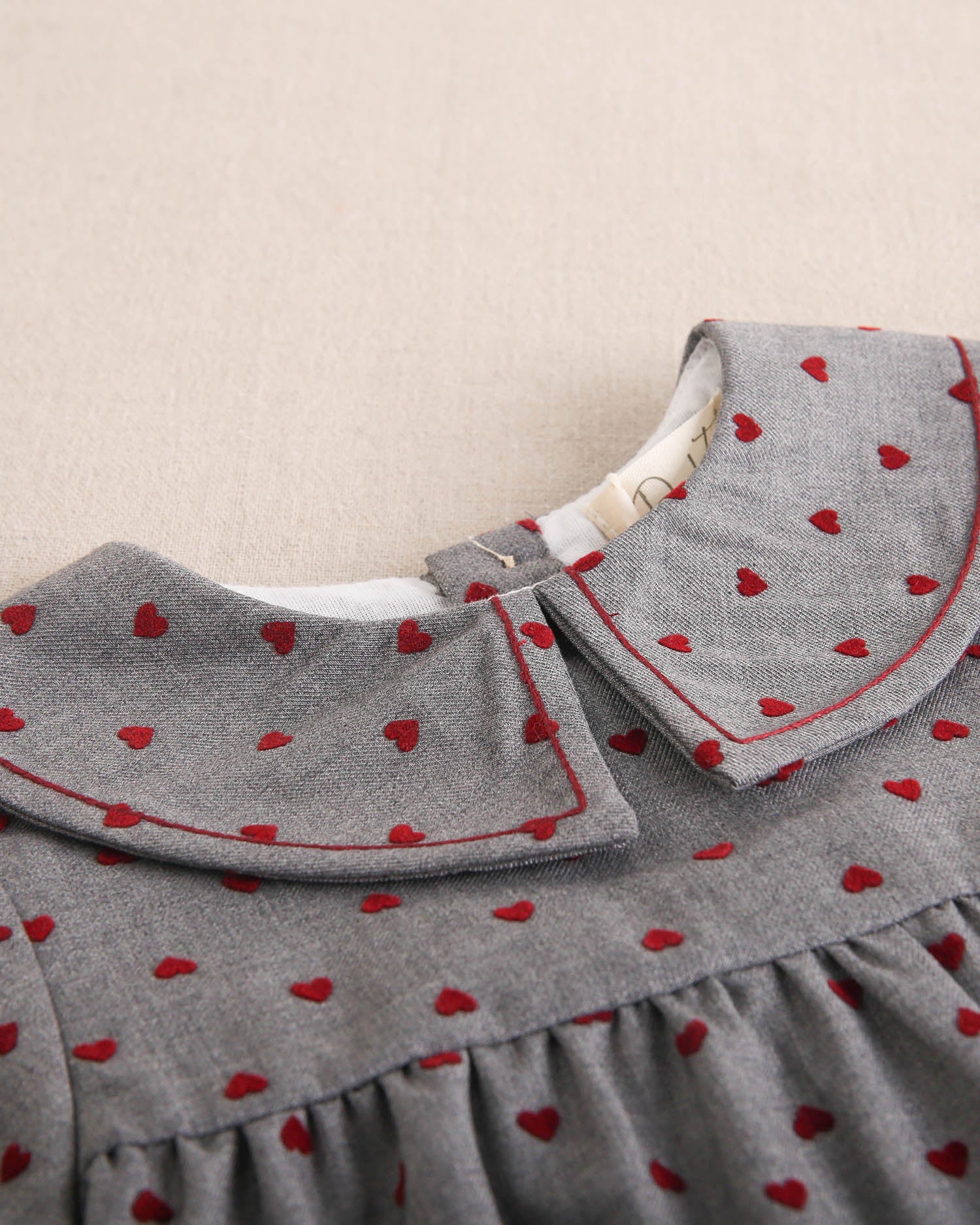 Vestido de bebé niña gris con estampado de corazones granate