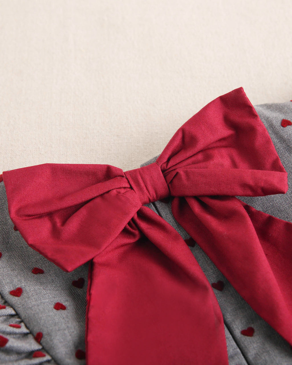 Vestido de niña gris con estampado de corazones granate