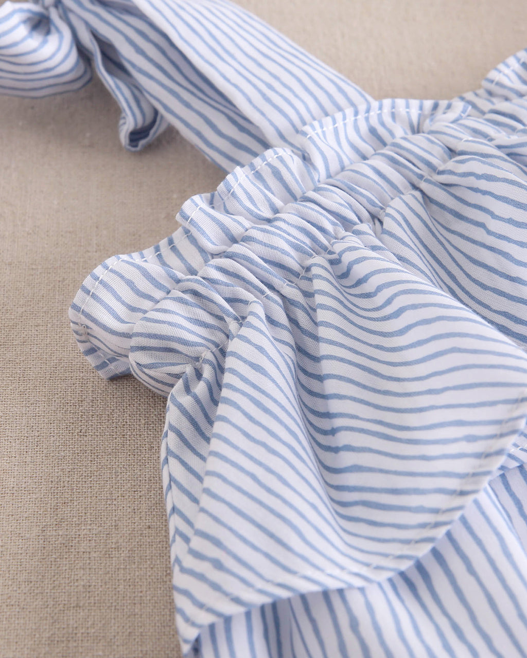 Blusa niña de rayas azules pastel y blancas con lazos en tirantes y volante