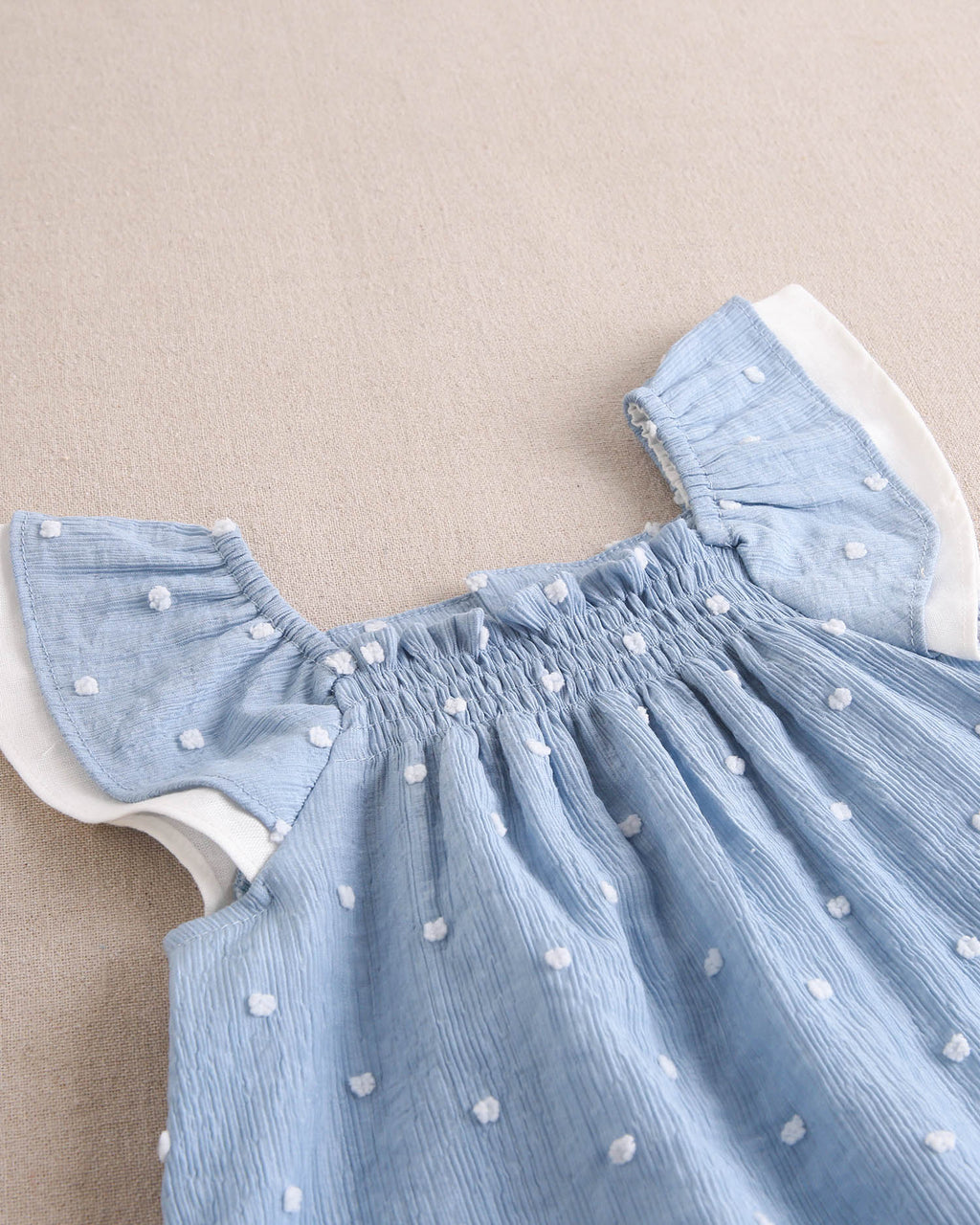 Vestido bebé niña de plumeti azul con topos blancos y volante en hombros