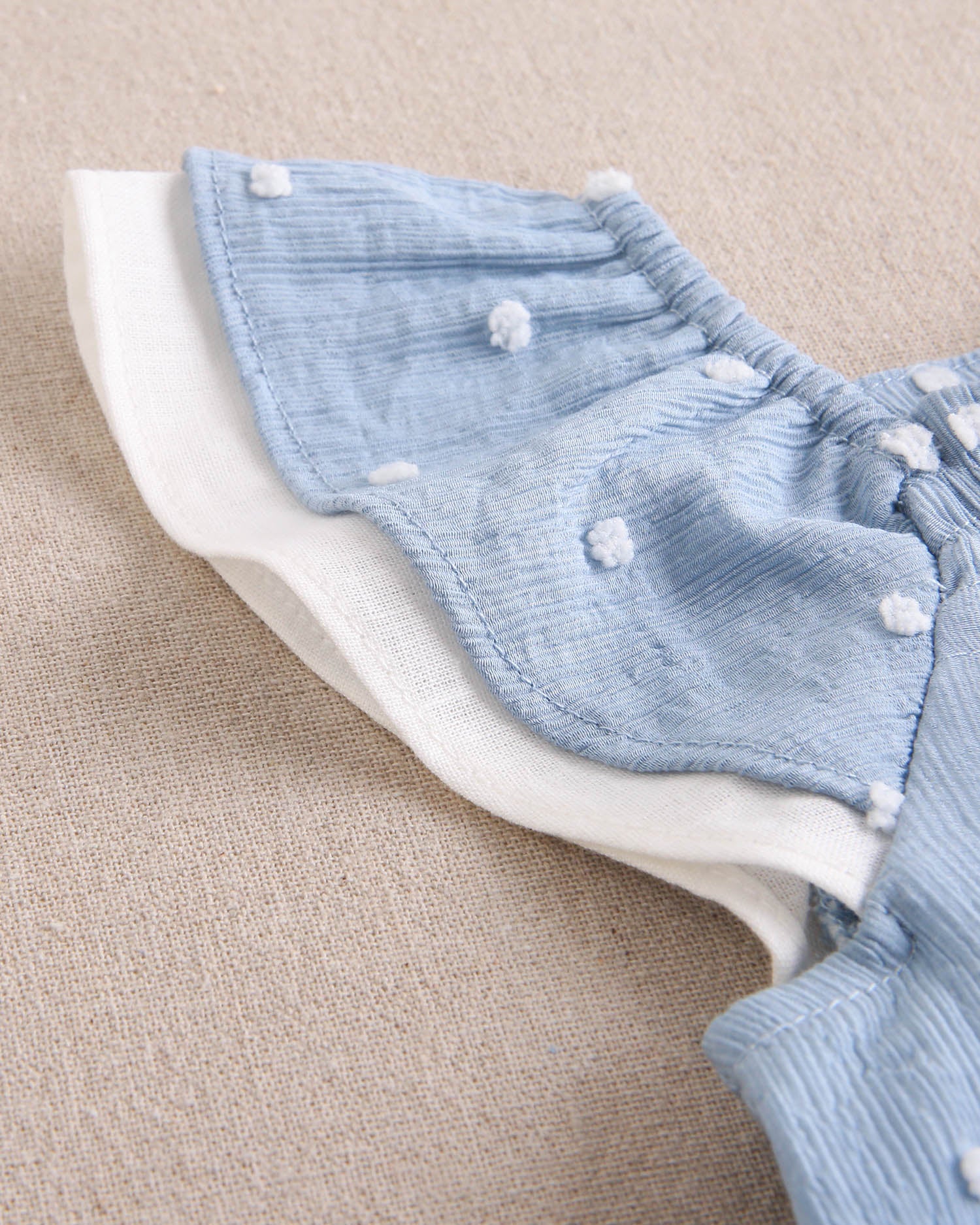 Vestido bebé niña de plumeti azul con topos blancos y volante en hombros