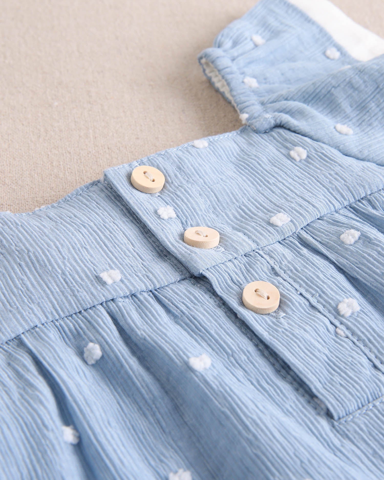 Vestido bebé niña de plumeti azul con topos blancos y volante en hombros