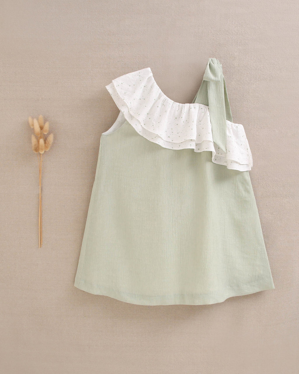 Vestido niña verde pastel con volante blanco de estrellas asimétrico y lazo en tirante