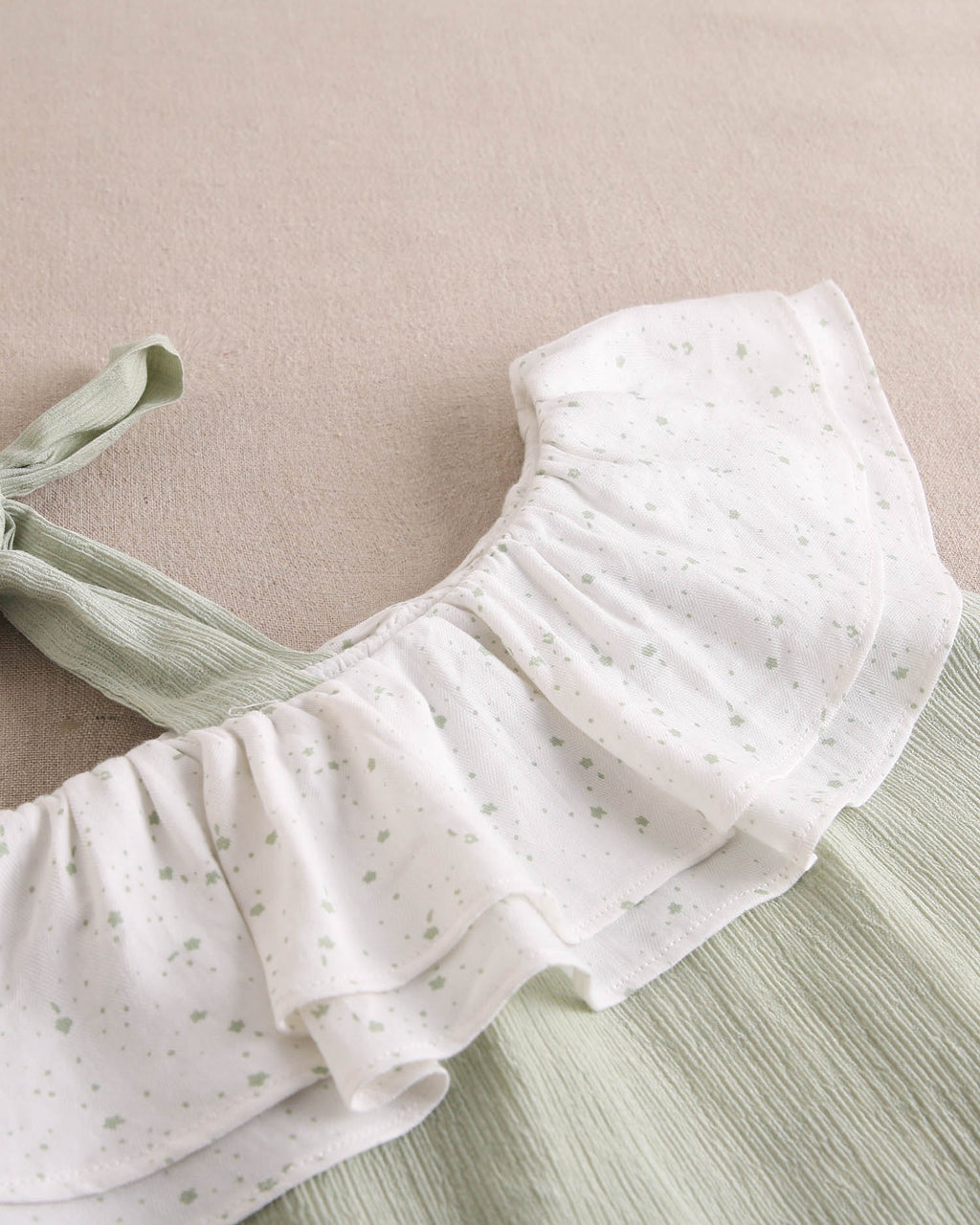 Vestido niña verde pastel con volante blanco de estrellas asimétrico y lazo en tirante