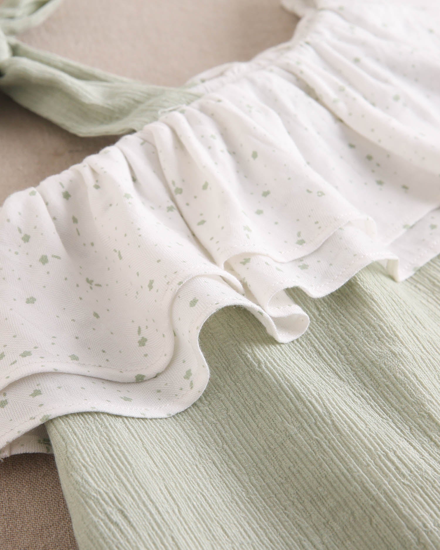 Vestido niña verde pastel con volante blanco de estrellas asimétrico y lazo en tirante