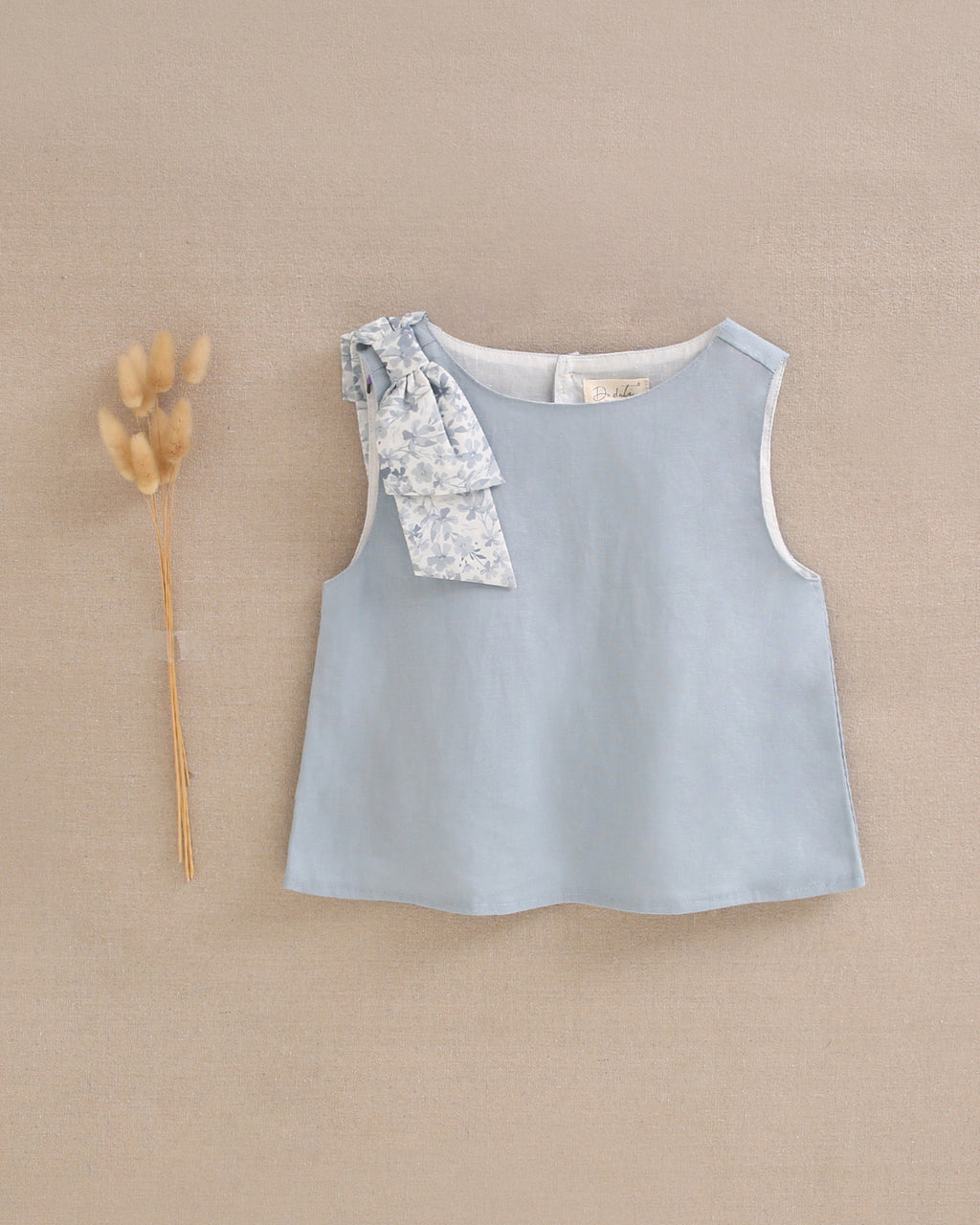 Blusa niña azul con lazo en tirante de flores  y abertura espalda