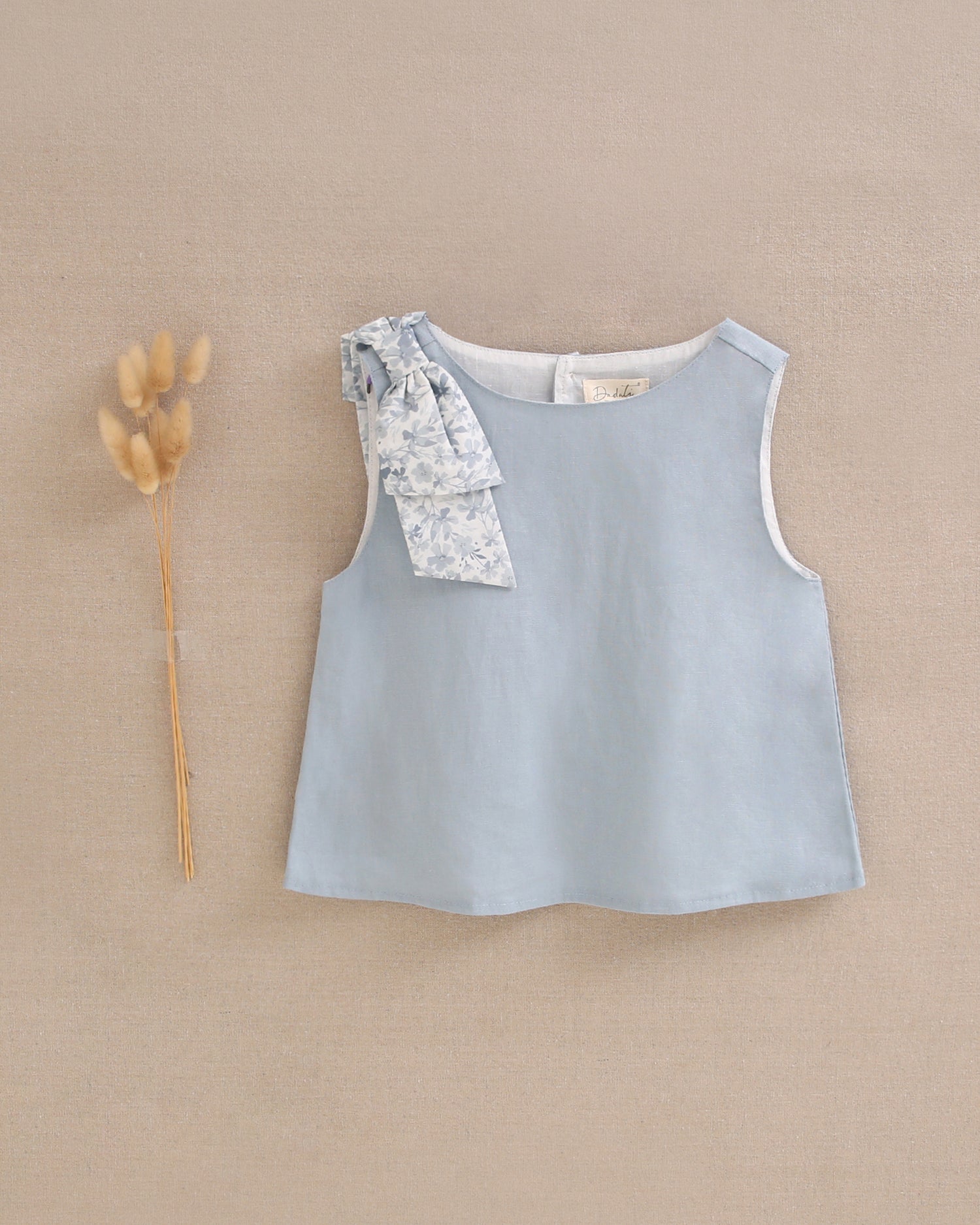 Blusa niña azul con lazo en tirante de flores  y abertura espalda