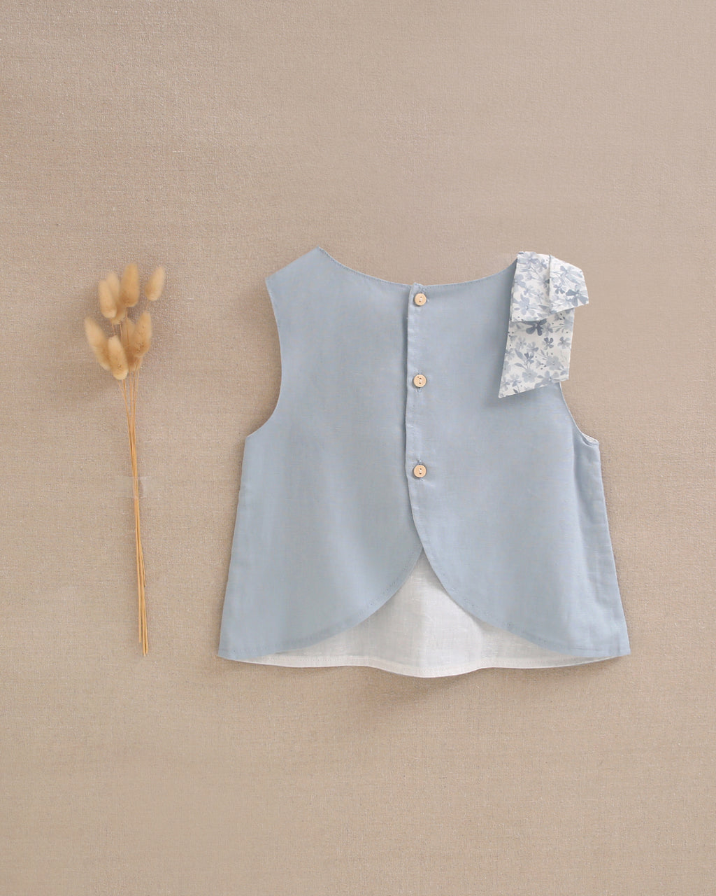 Blusa niña azul con lazo en tirante de flores  y abertura espalda