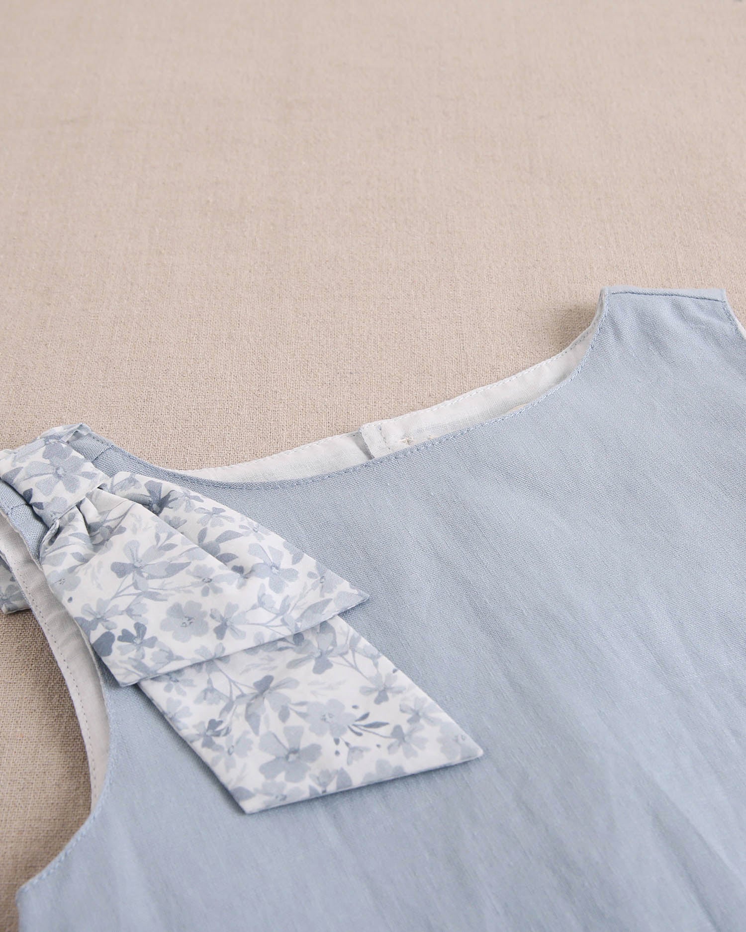 Blusa niña azul con lazo en tirante de flores  y abertura espalda