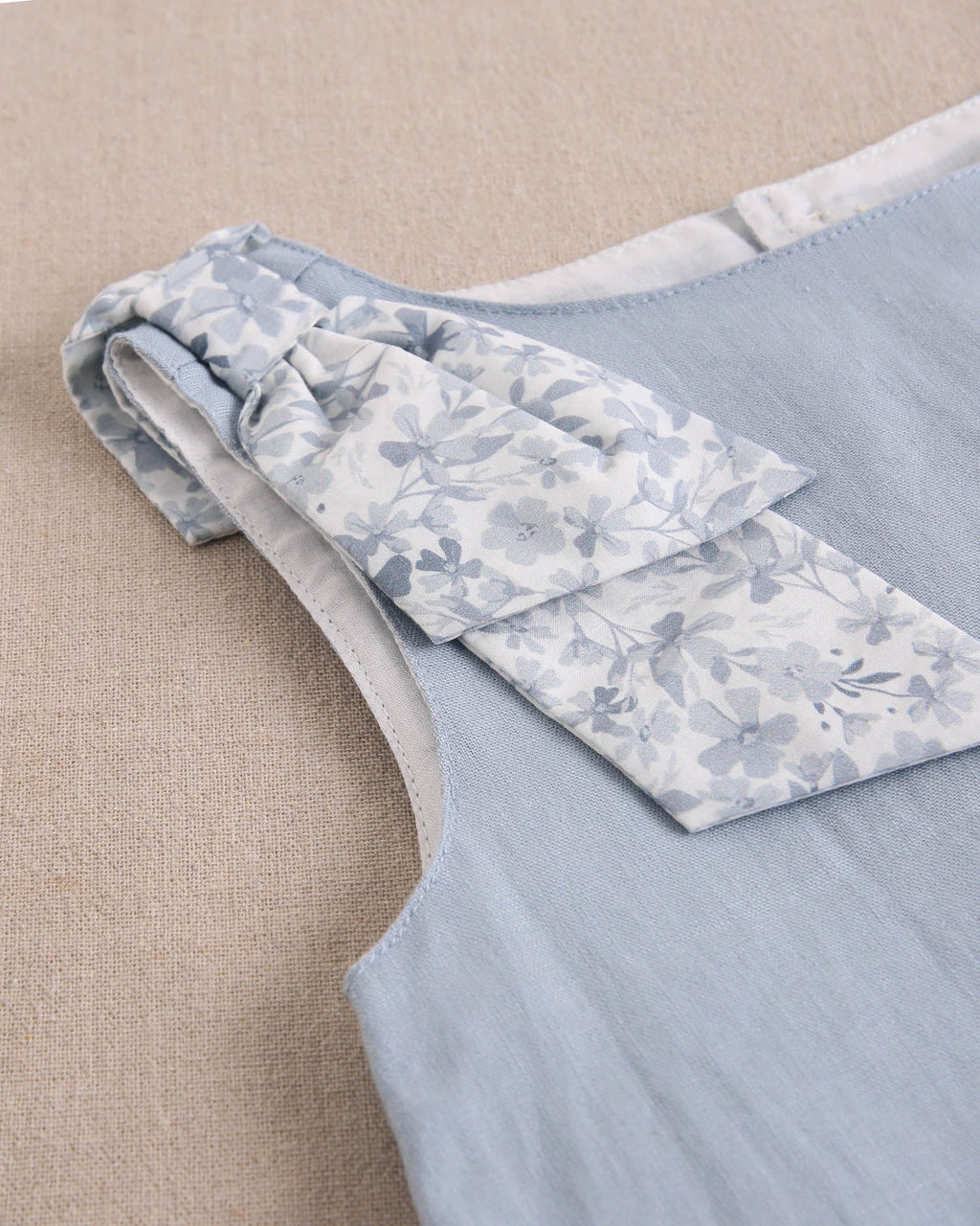 Blusa niña azul con lazo en tirante de flores  y abertura espalda