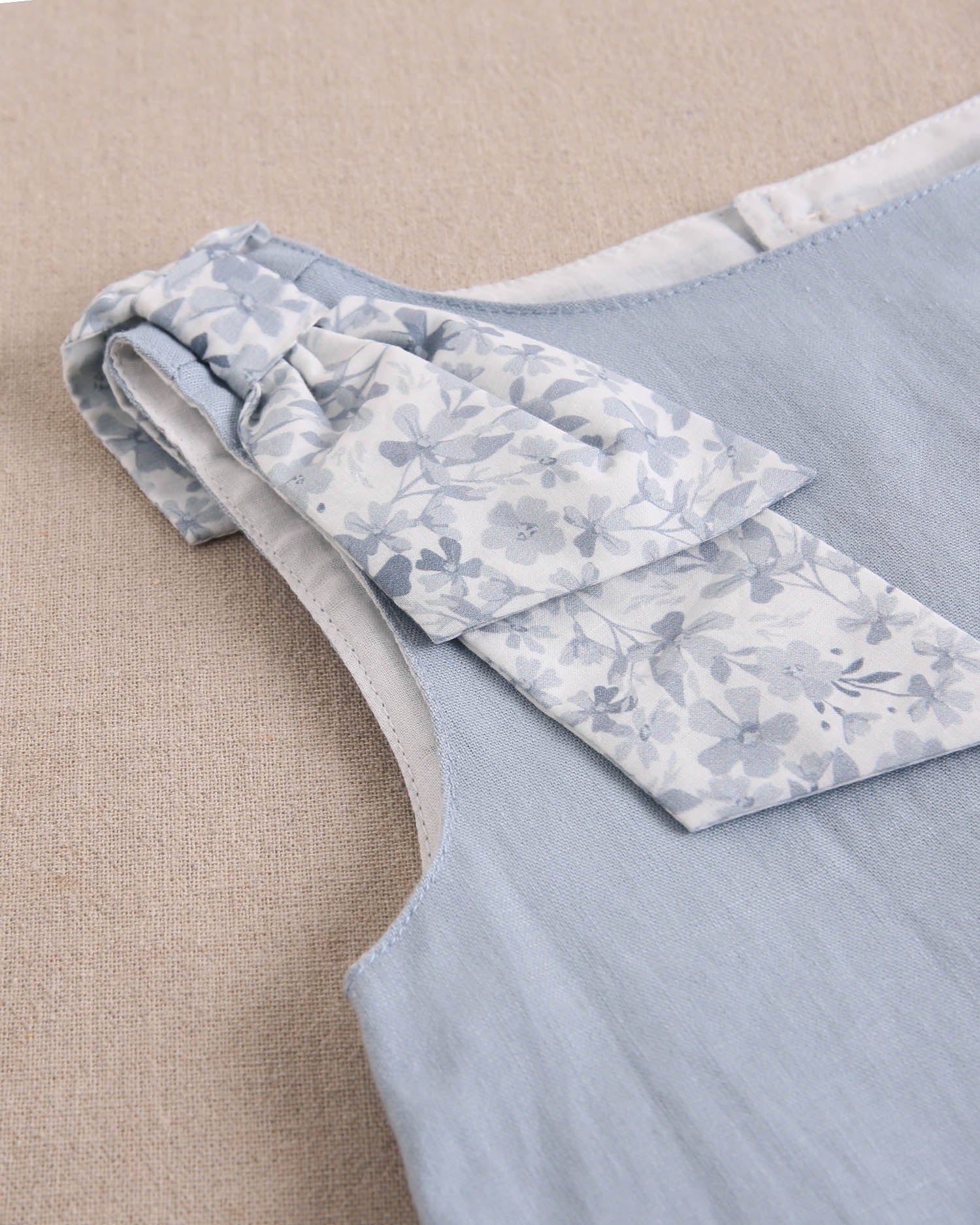 Blusa niña azul con lazo en tirante de flores  y abertura espalda