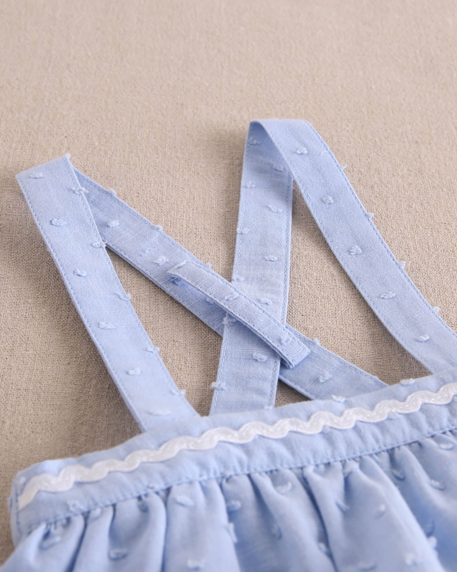 Ranita bebé niña tipo pichi de plumeti azul con ribete blanco