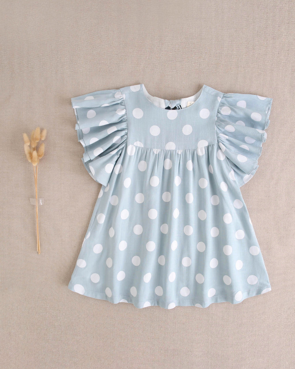 Vestido de niña azul cielo con lunares blancos y lazo en espalda