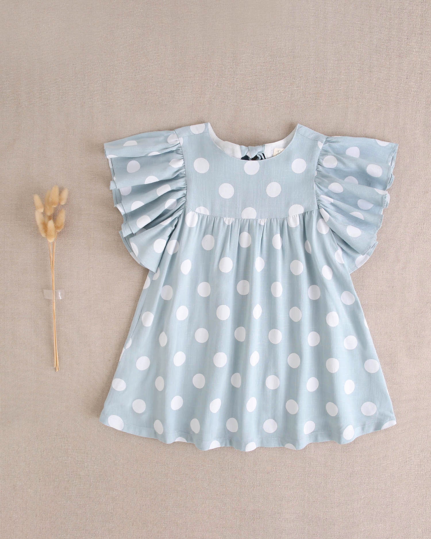 Vestido de niña azul cielo con lunares blancos y lazo en espalda