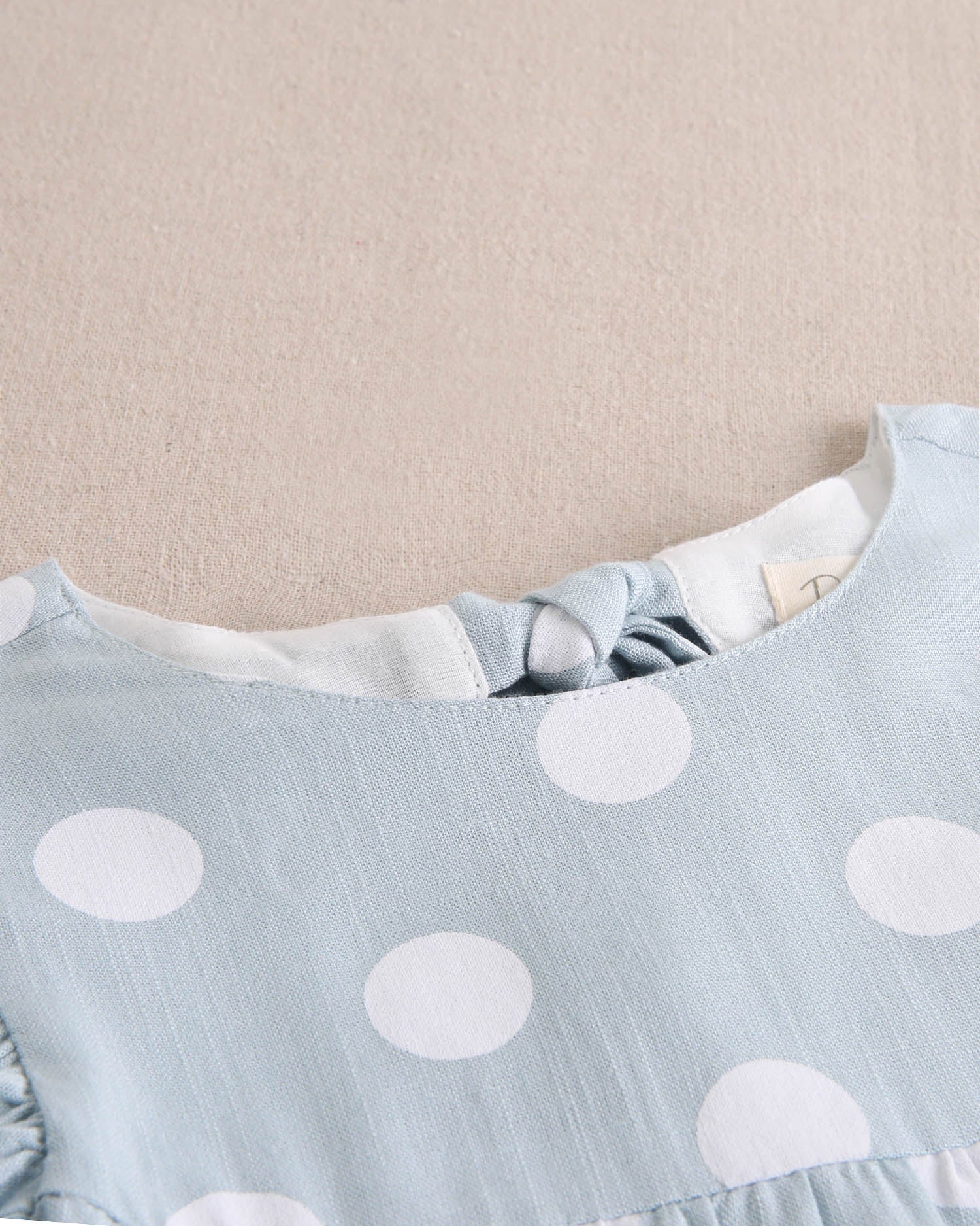 Vestido de niña azul cielo con lunares blancos y lazo en espalda