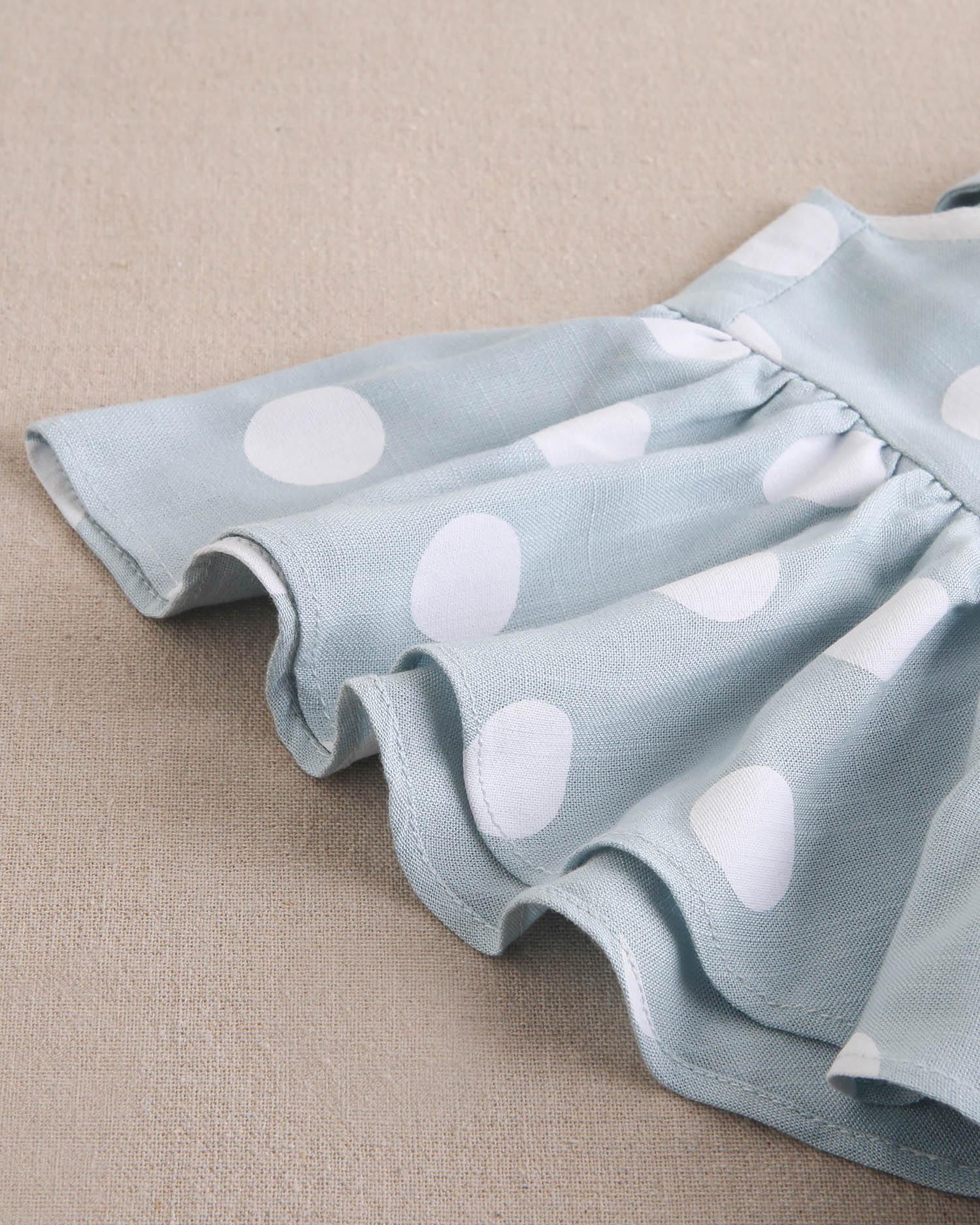 Vestido de niña azul cielo con lunares blancos y lazo en espalda