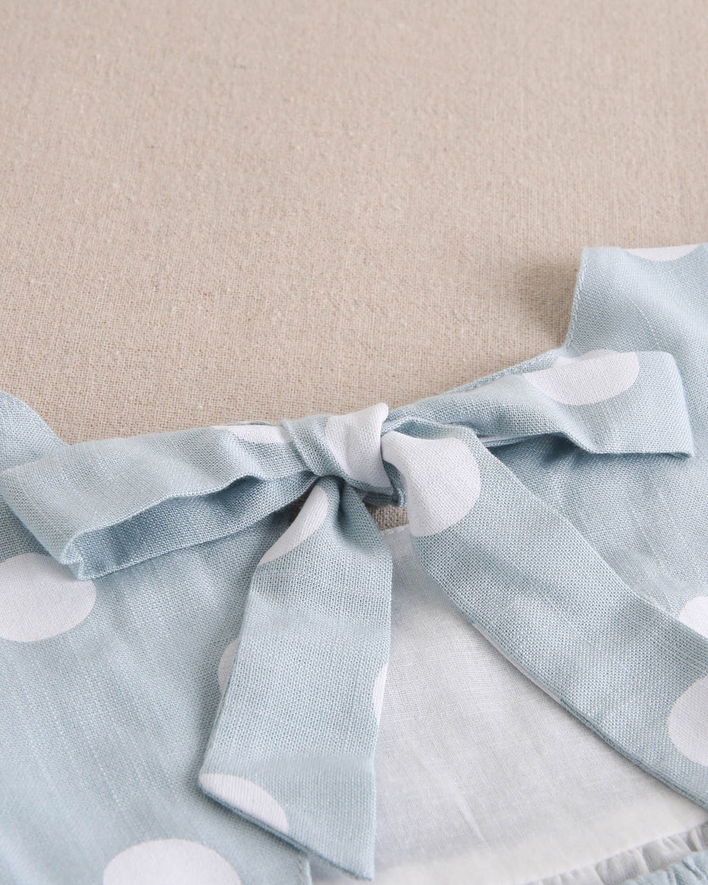 Vestido de niña azul cielo con lunares blancos y lazo en espalda