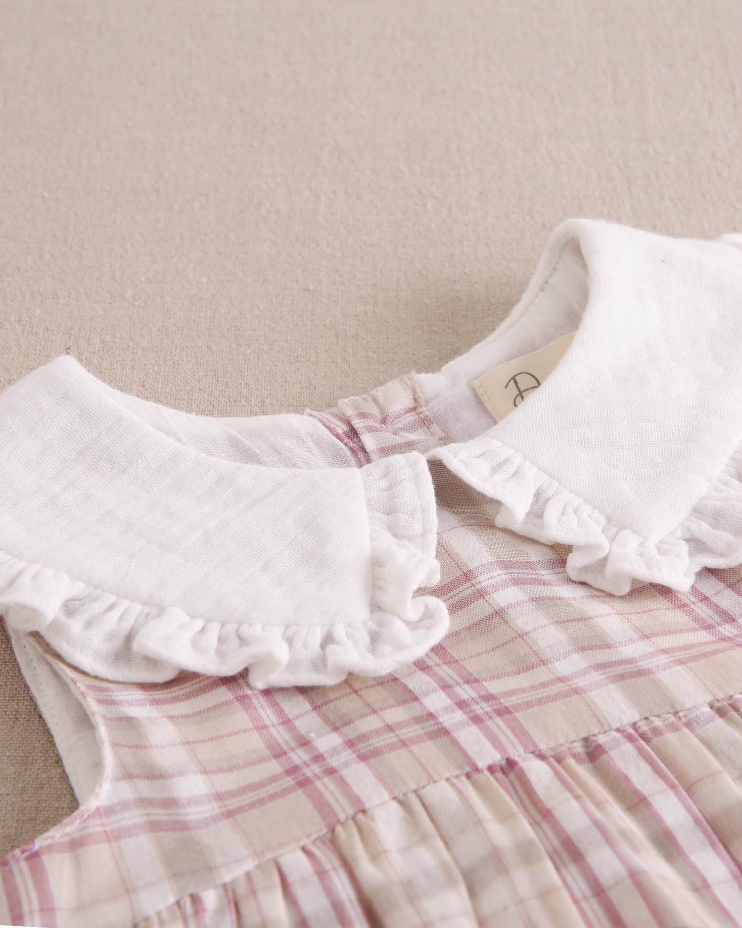 Vestido bebé niña de cuadros rosas, marrones y blancos, con cuello blanco