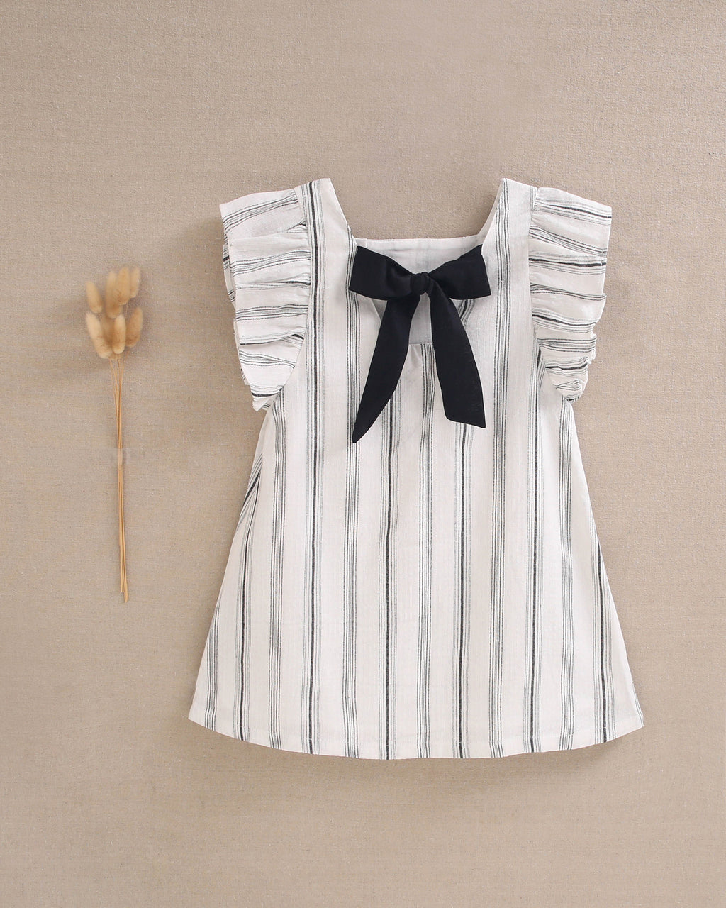 Vestido de niña en rayas negras y blancas y lazo negro en espalda