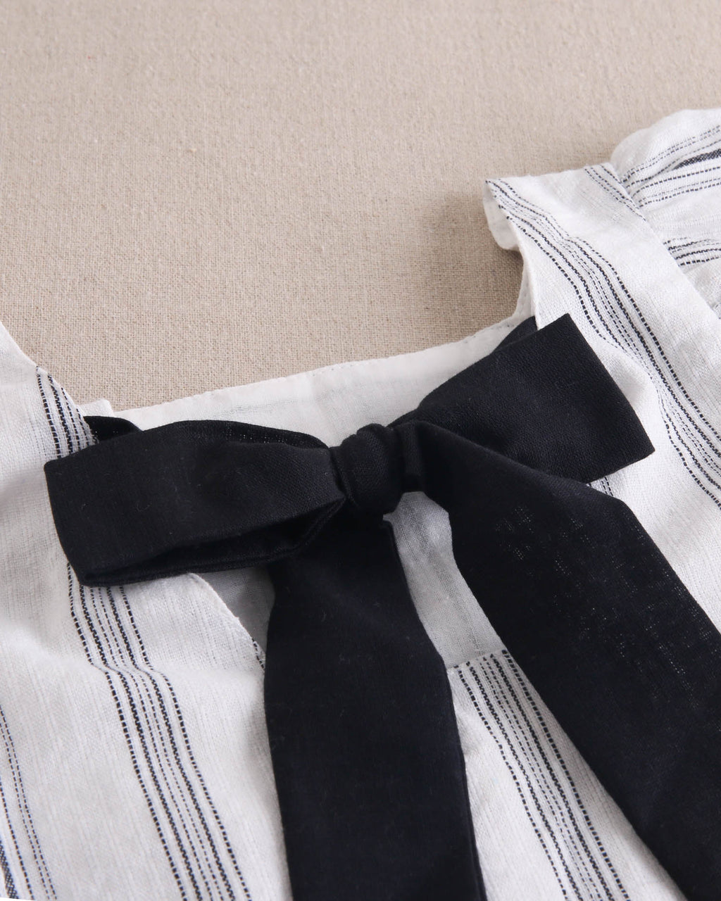 Vestido de niña en rayas negras y blancas y lazo negro en espalda