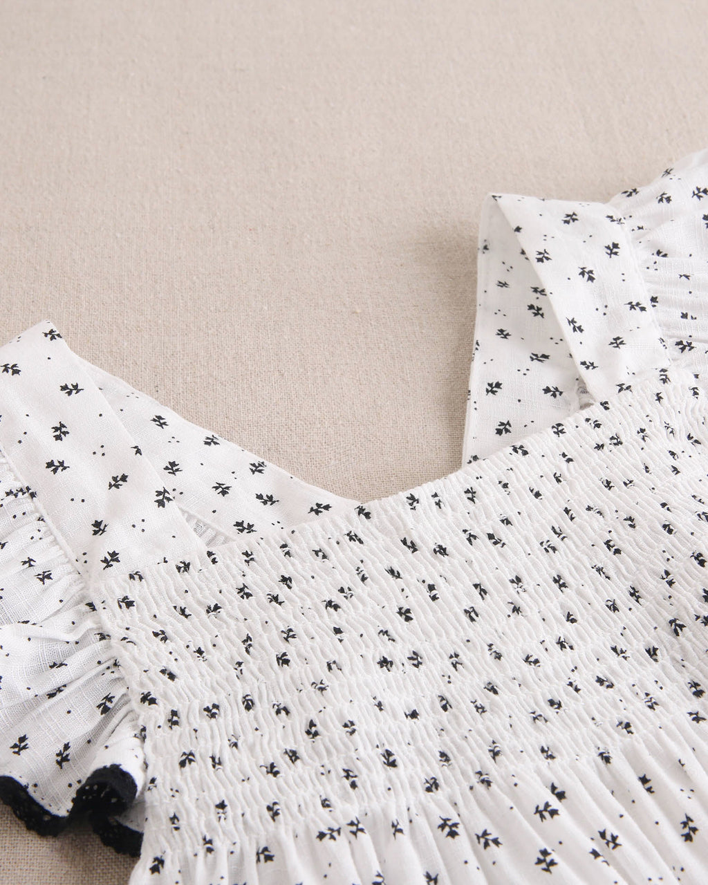 Vestido niña blanco con flores negras y mangas con bordes negros