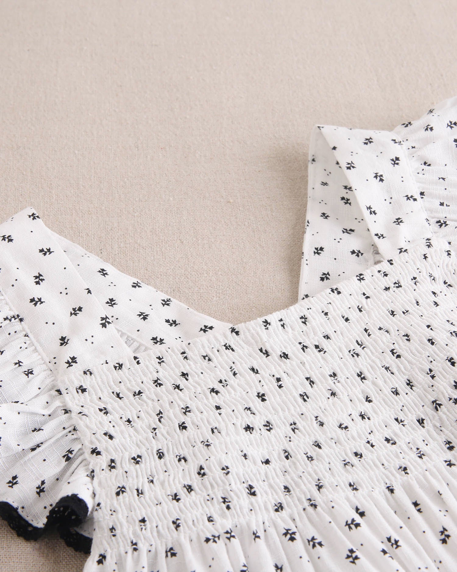 Vestido niña blanco con flores negras y mangas con bordes negros