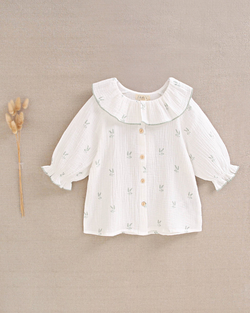 Blusa niña de muselina crudo con estampado de ramas verde pastel y cuello volante