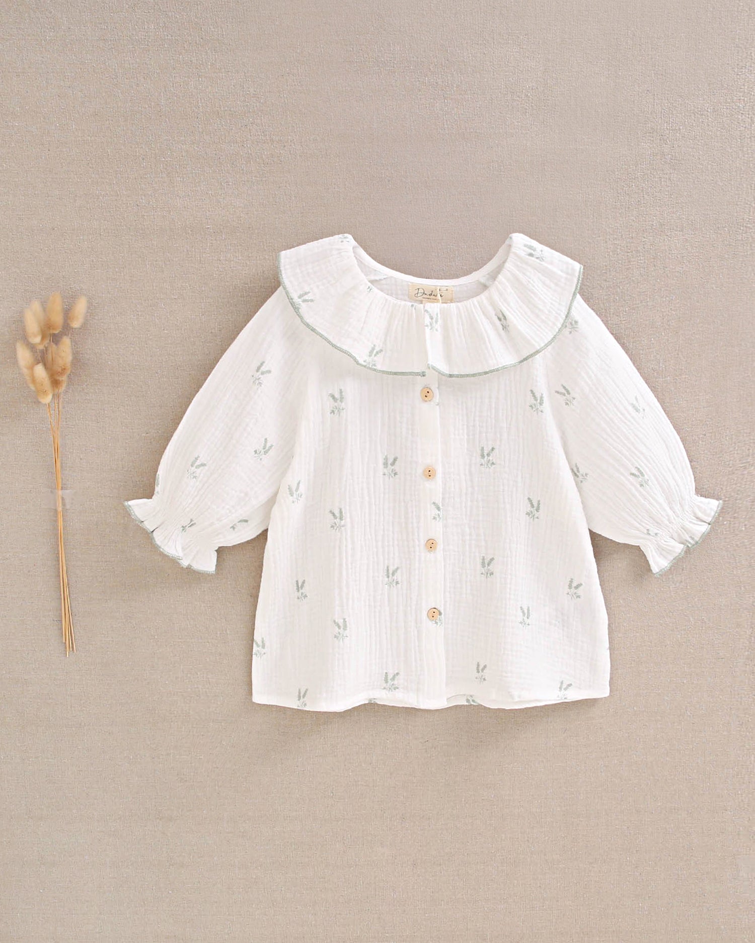Blusa niña de muselina crudo con estampado de ramas verde pastel y cuello volante