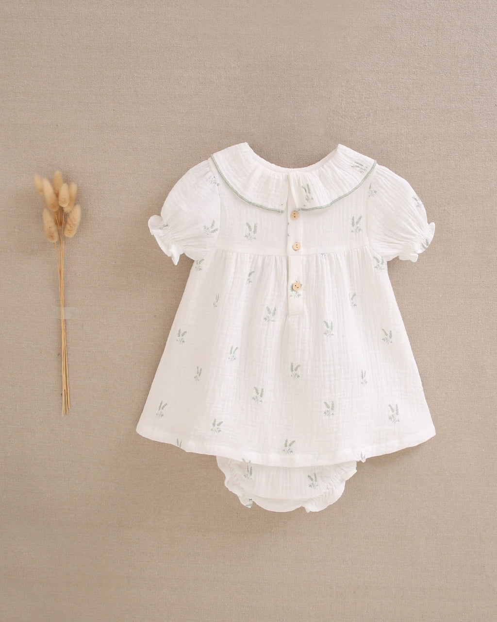 Vestido bebé niña crudo con estampado de ramas verde pastel