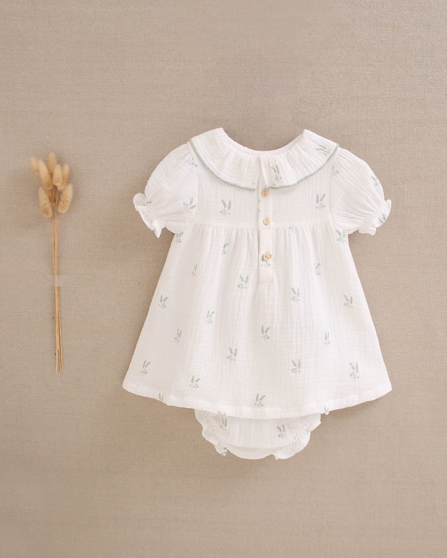 Vestido bebé niña crudo con estampado de ramas verde pastel