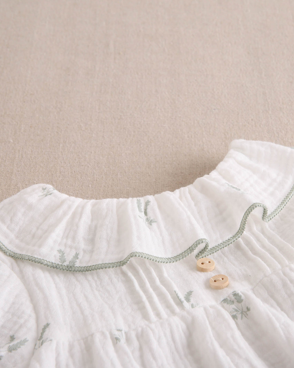 Vestido bebé niña crudo con estampado de ramas verde pastel
