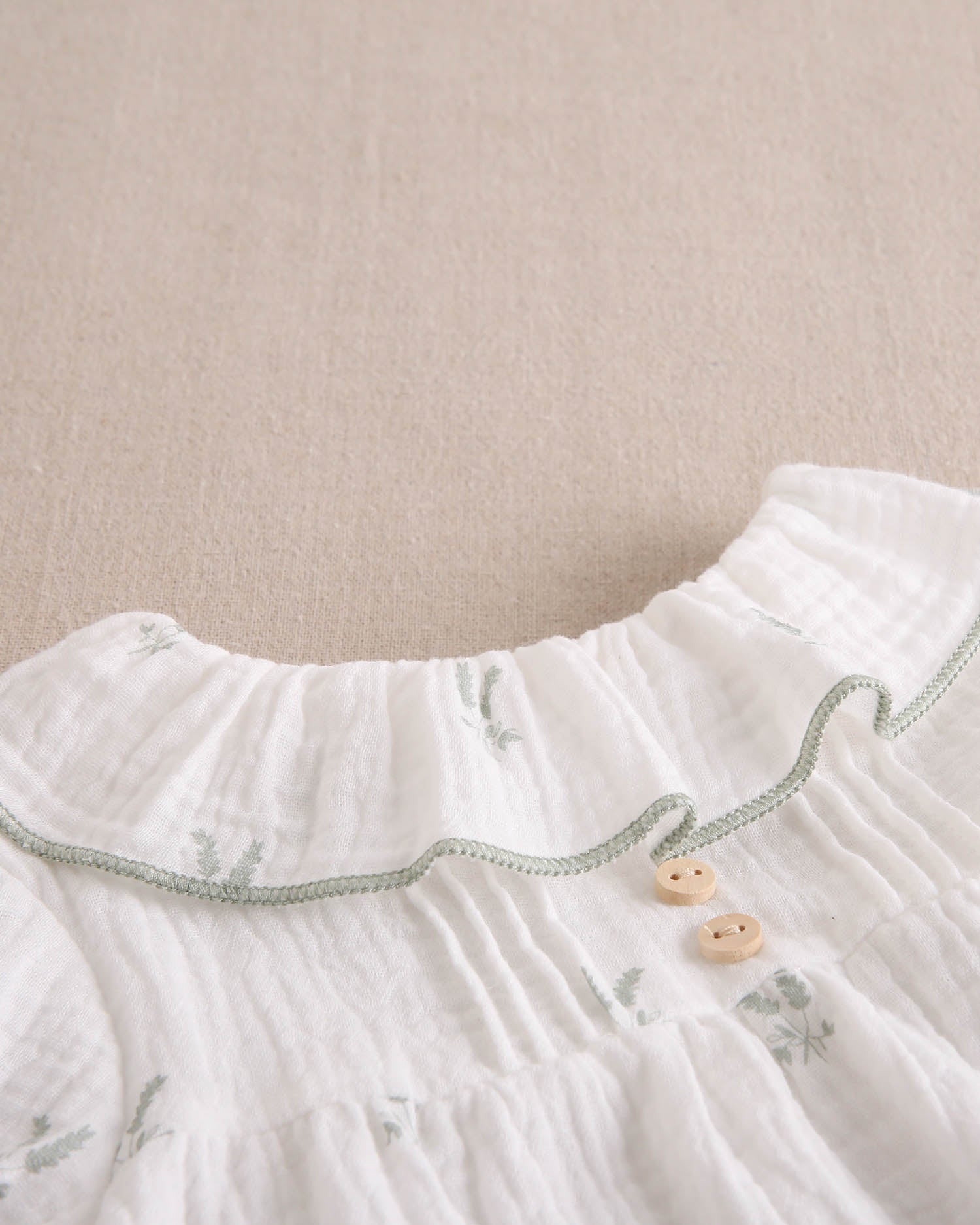 Vestido bebé niña crudo con estampado de ramas verde pastel