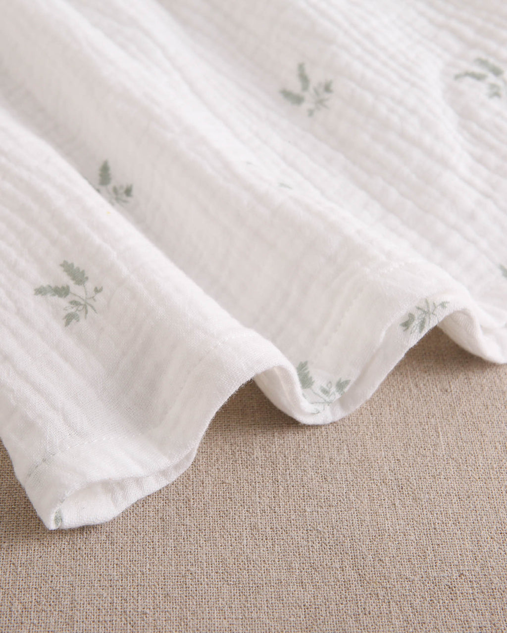 Vestido bebé niña crudo con estampado de ramas verde pastel