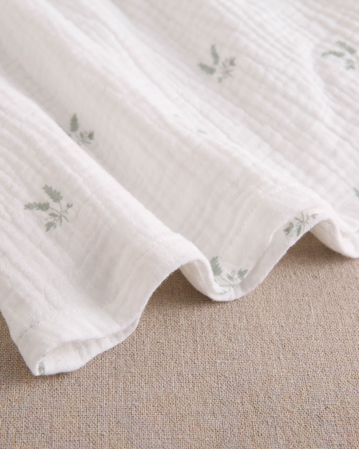 Vestido bebé niña crudo con estampado de ramas verde pastel