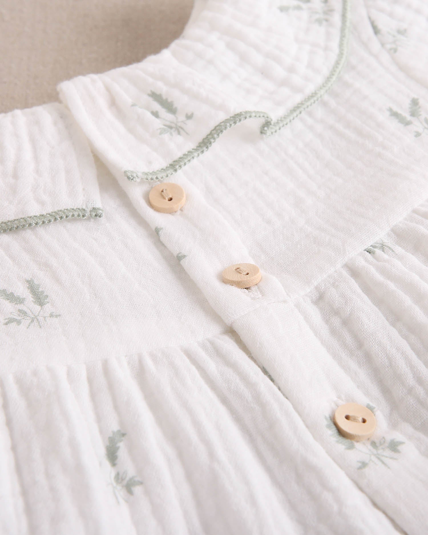 Vestido bebé niña crudo con estampado de ramas verde pastel