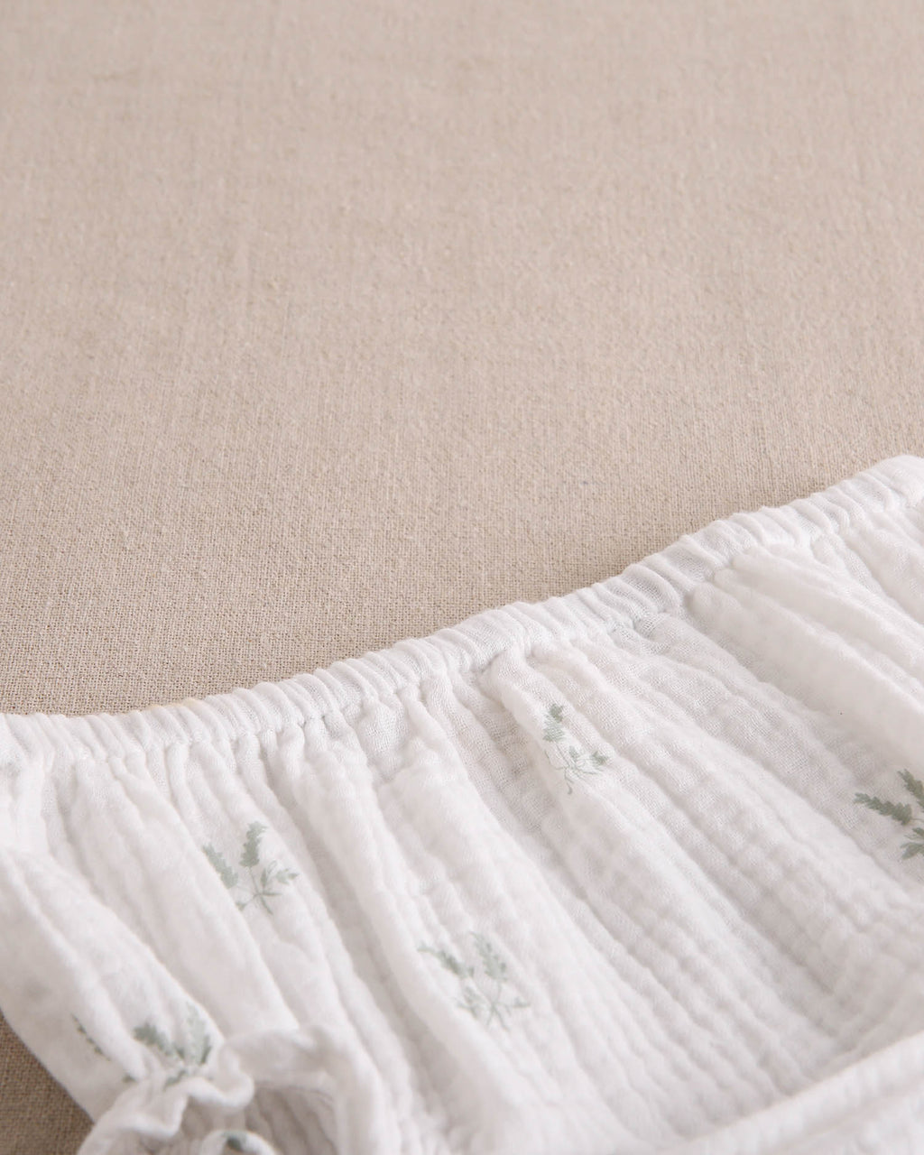 Vestido bebé niña crudo con estampado de ramas verde pastel