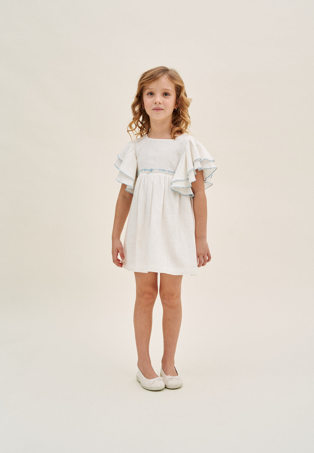 Vestido niña blanco con bordes en azul y lazo en espalda de plumeti azul