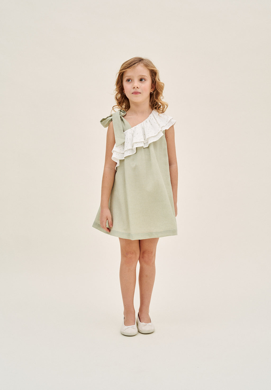 Vestido niña verde pastel con volante blanco de estrellas asimétrico y lazo en tirante