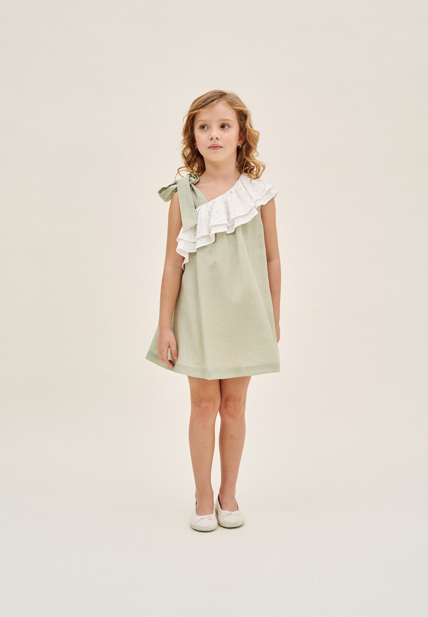 Vestido niña verde pastel con volante blanco de estrellas asimétrico y lazo en tirante