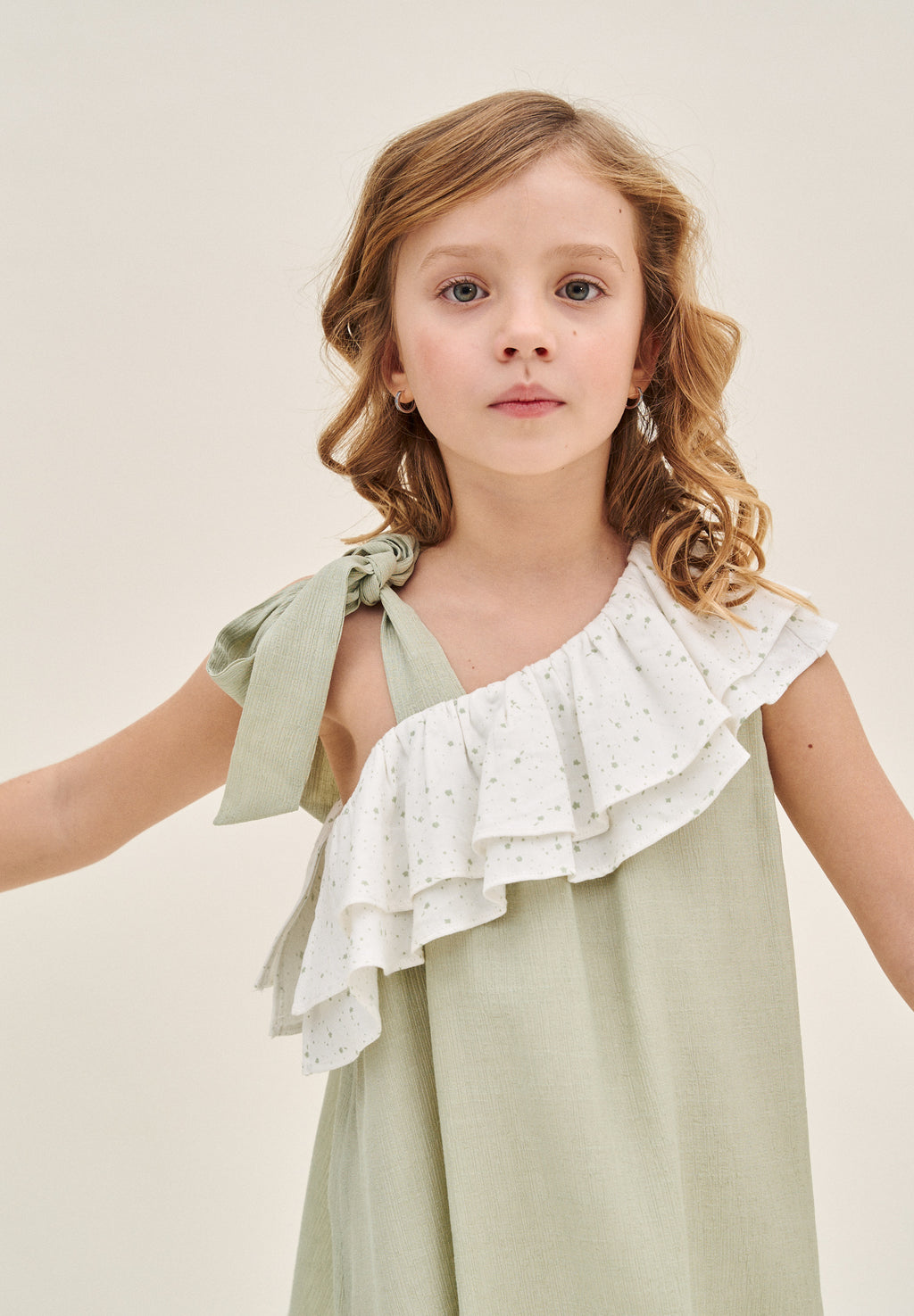 Vestido niña verde pastel con volante blanco de estrellas asimétrico y lazo en tirante