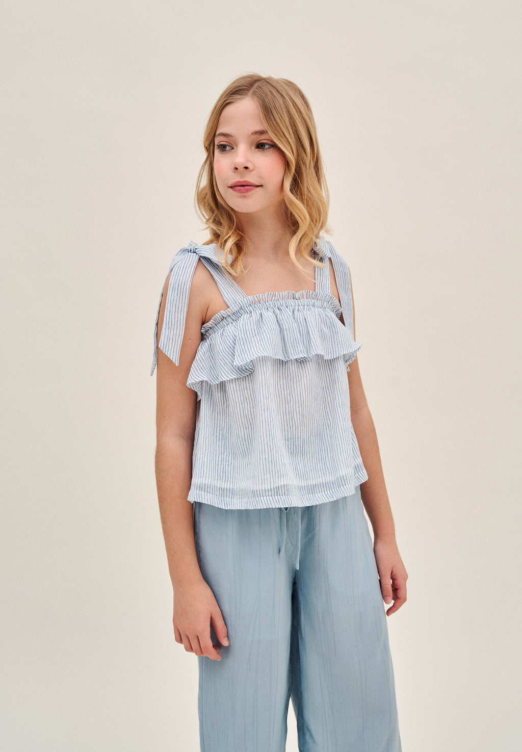 Blusa niña de rayas azules pastel y blancas con lazos en tirantes y volante