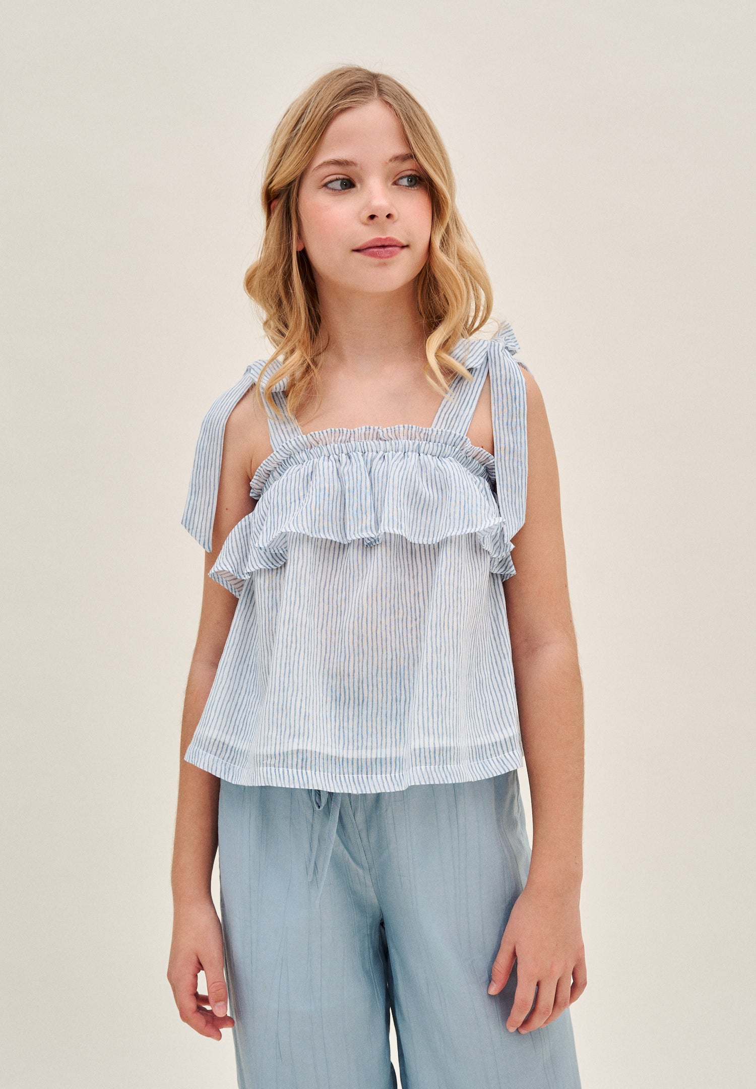 Blusa niña de rayas azules pastel y blancas con lazos en tirantes y volante