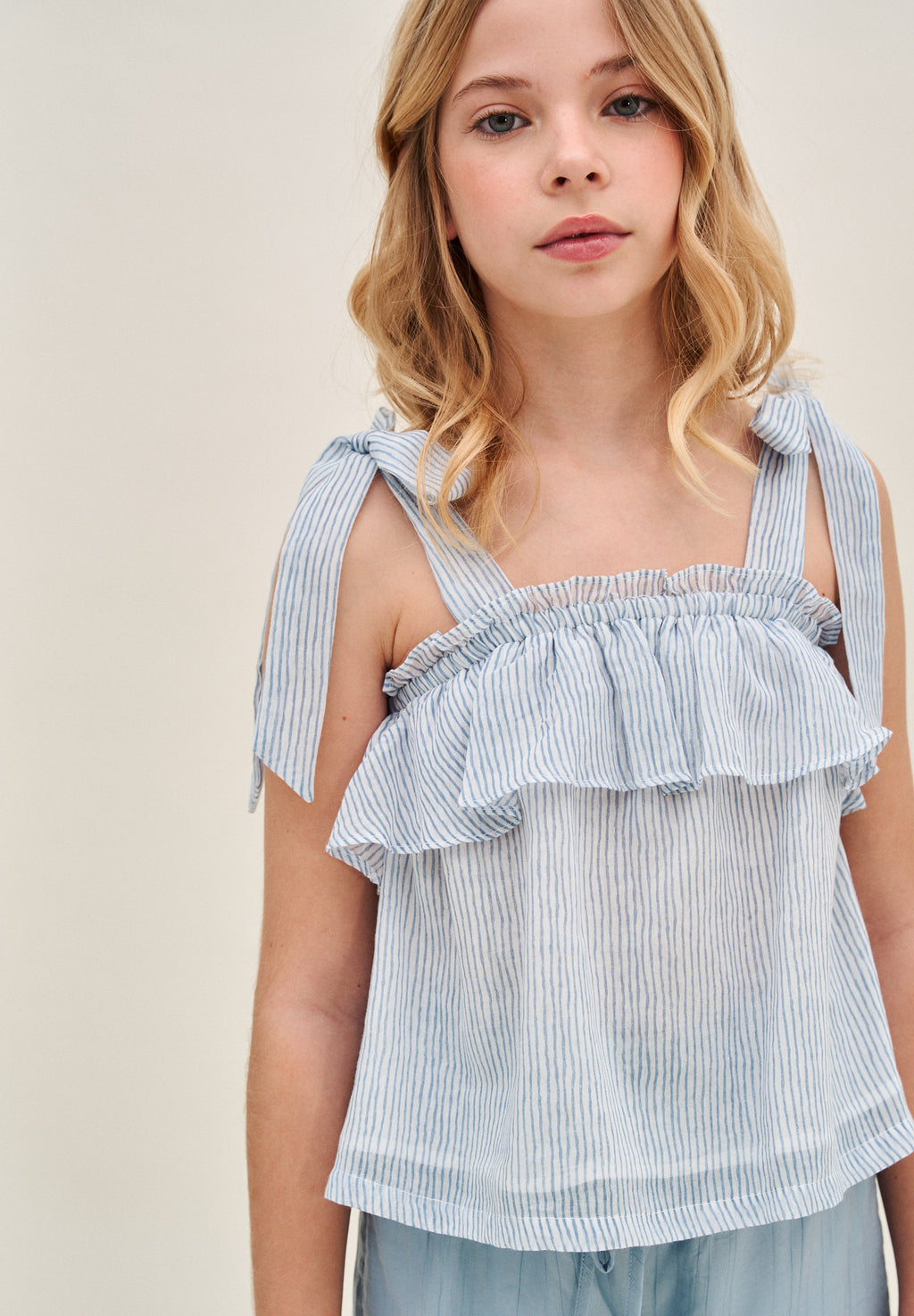 Blusa niña de rayas azules pastel y blancas con lazos en tirantes y volante