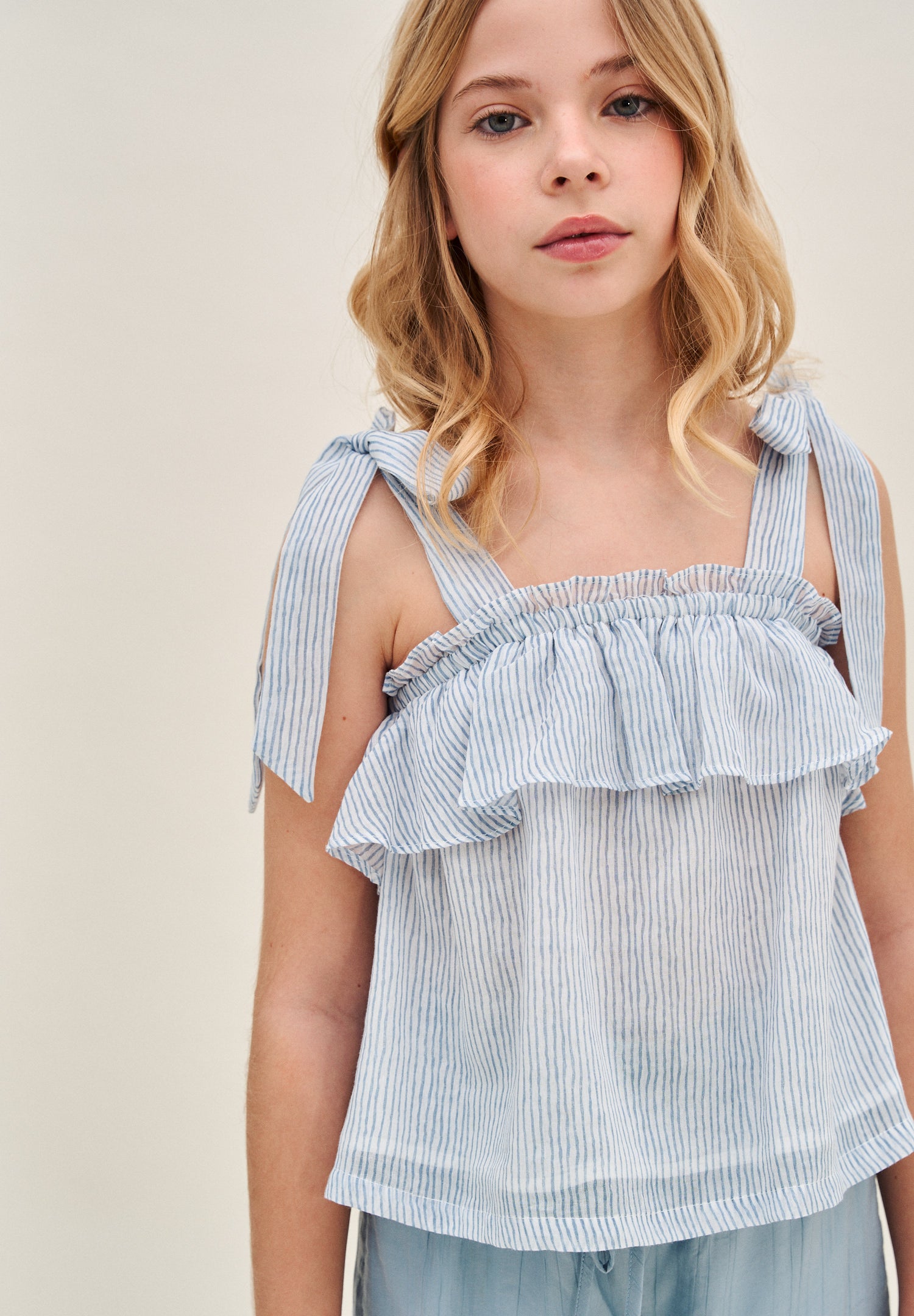 Blusa niña de rayas azules pastel y blancas con lazos en tirantes y volante