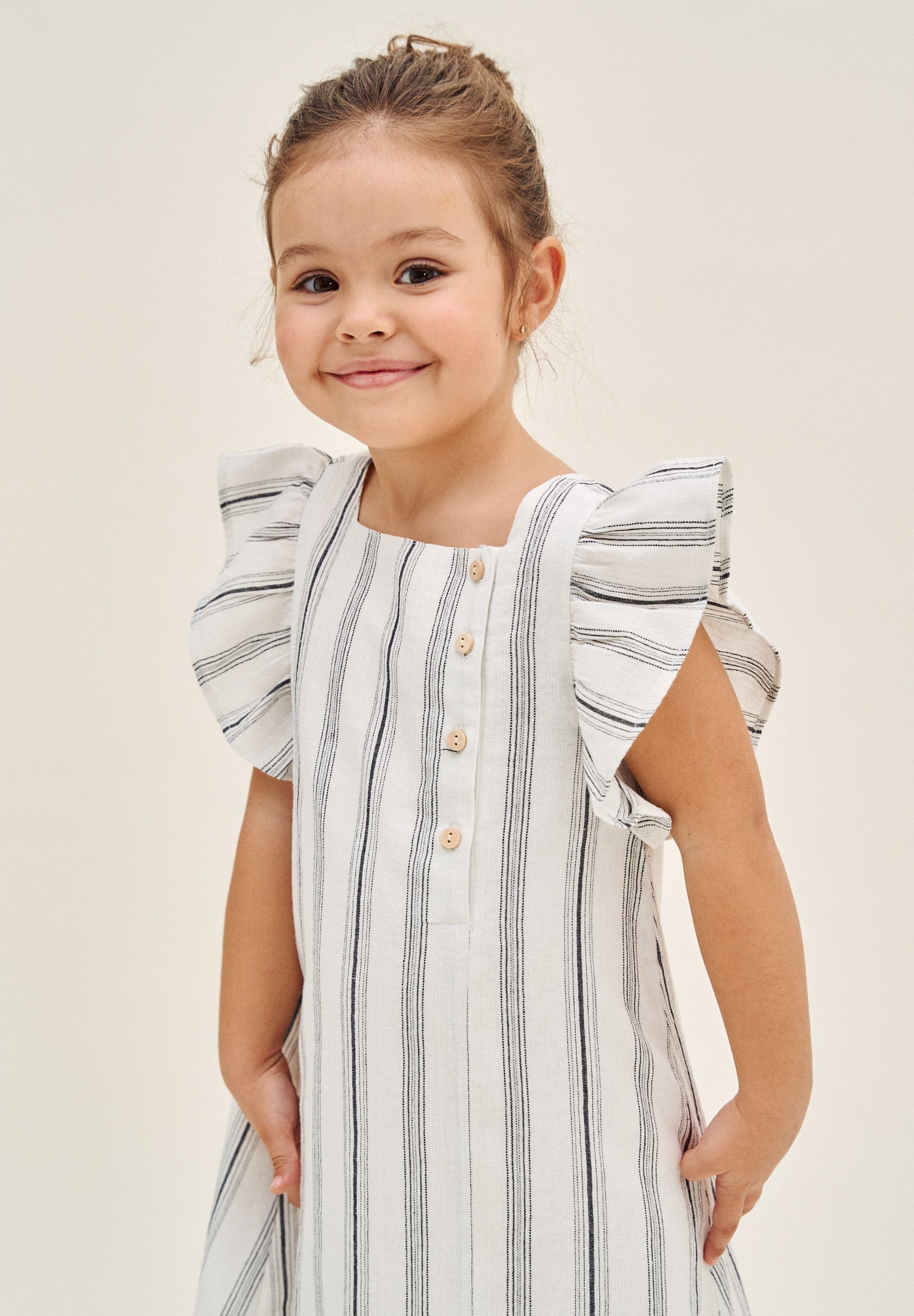 Vestido de niña en rayas negras y blancas y lazo negro en espalda