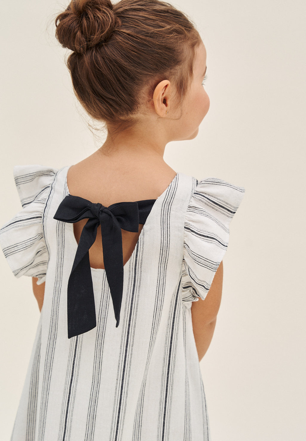 Vestido de niña en rayas negras y blancas y lazo negro en espalda