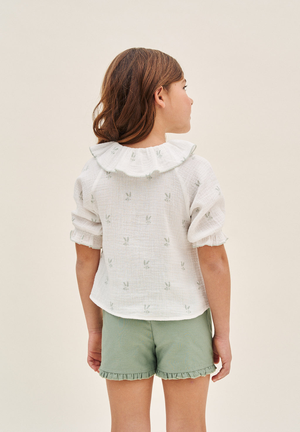 Blusa niña de muselina crudo con estampado de ramas verde pastel y cuello volante