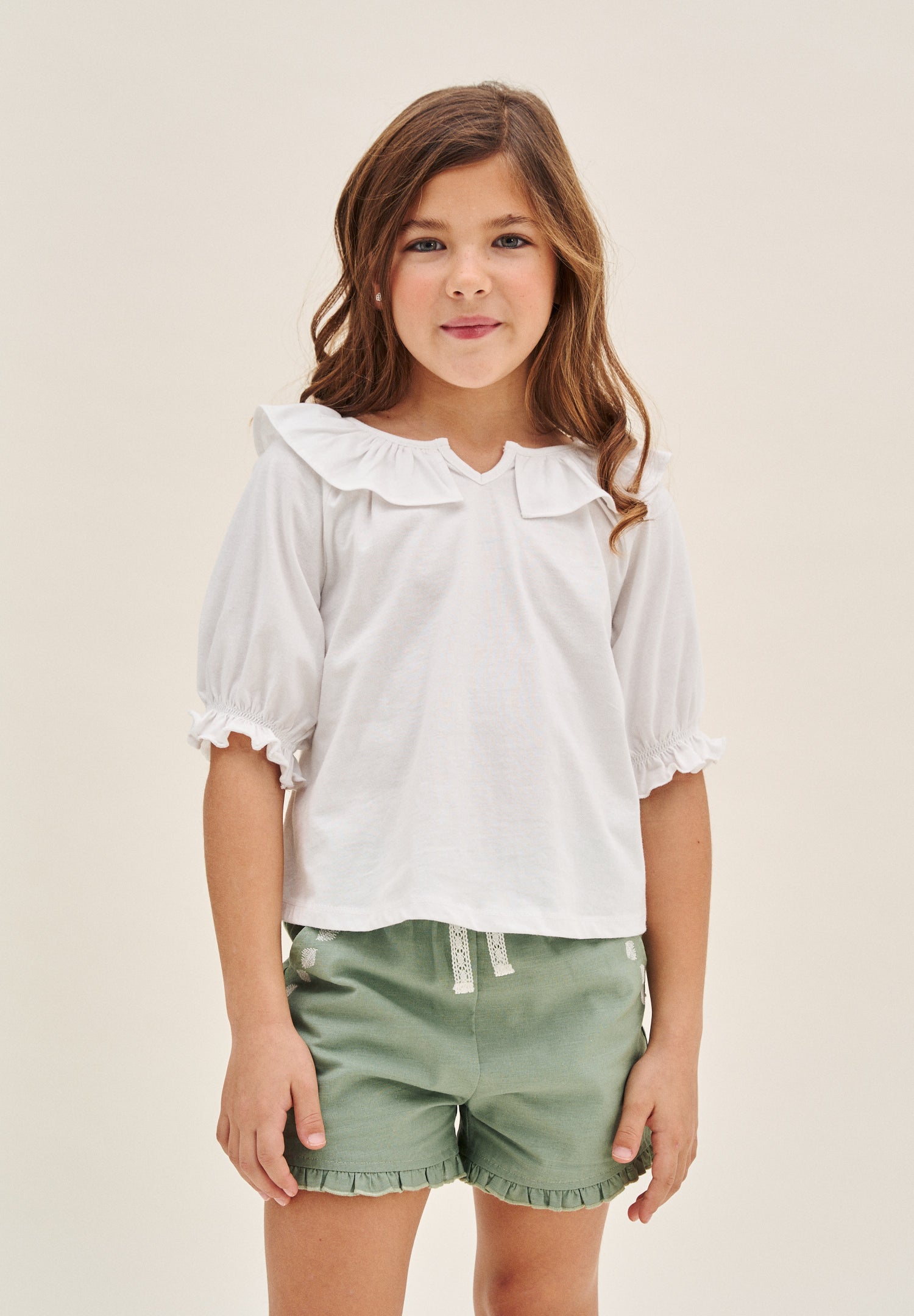 Camiseta niña color  blanco manga 3/4 y cuello abierto con volantes