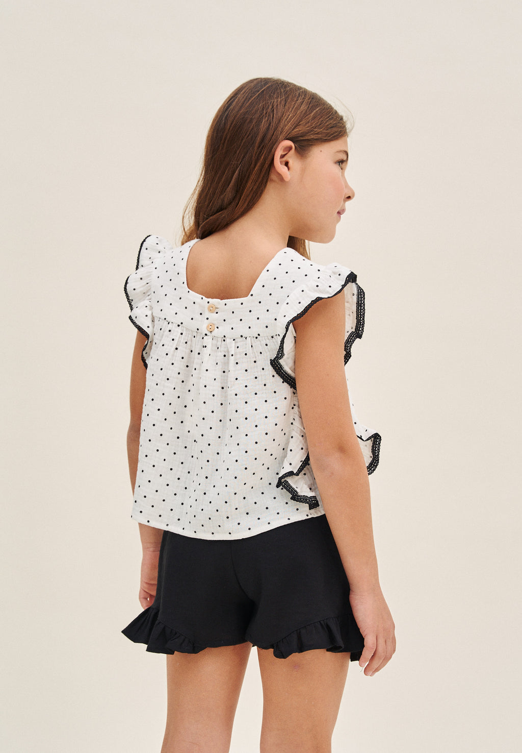 Blusa niña blanca con topitos y contraste negro